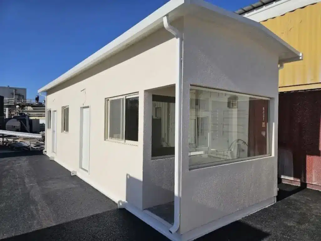 ביתן שומר יביל לבן עם חלונות היקפיים וגג משופע