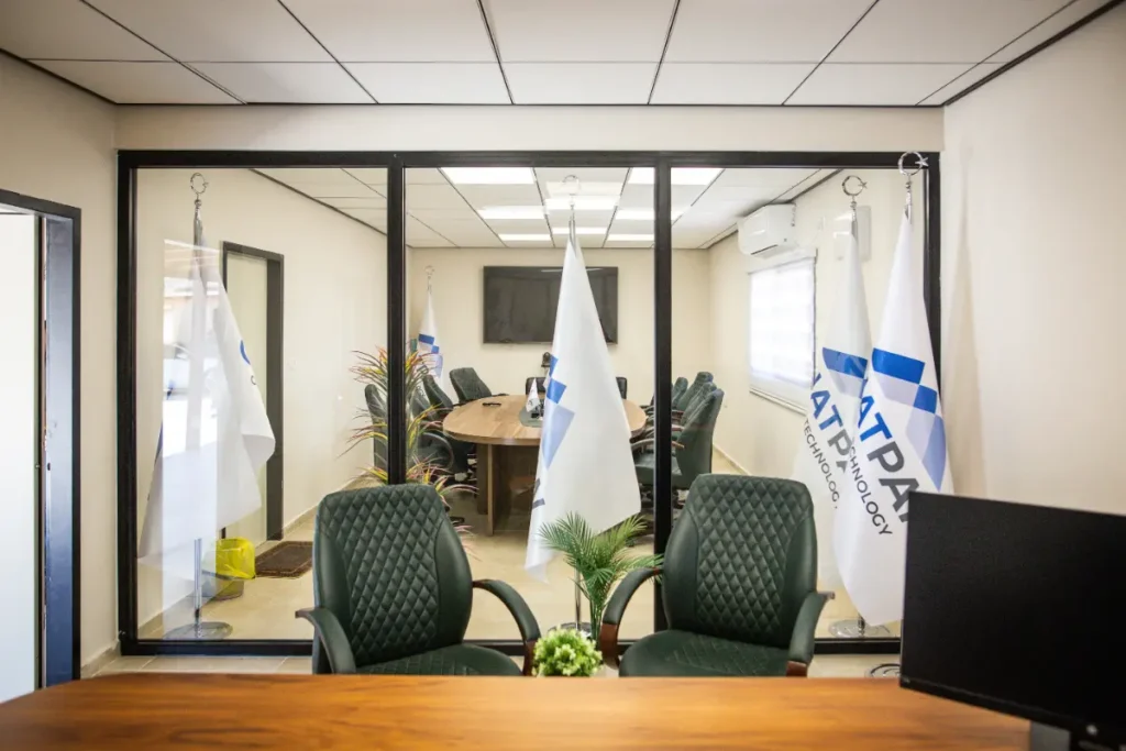 משרד במבנה יביל עם שולחן ישיבות, כיסאות, דגלים ומחיצת זכוכית